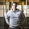 Andrew Tomasetti poses for a photo in his company branded sweatshirt.