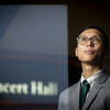 Trevor Tran poses for a photo by a concert hall.