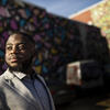 Andrew Ankamah poses in front of Philadelphia wall mural.
