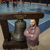 Joseph Curry stands with the Franklin Towne Bell. 
