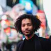 Honoree Jordan Dobson on the street in New York City with bright lights behind him
