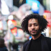 Honoree Jordan Dobson standing on an NYC street with bright lights behind him