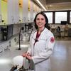 Honoree Haley Lockstein wearing a while labcoat and standing in a dental office