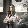 Honoree Haley Lockstein wearing a white lab coat and standing next to dental equipment