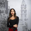 Honoree Binh Nguyen standing in front of a mural of Philadelphia City Hall