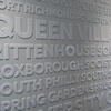 A closeup of a wall mural at Visit Philadelphia that displays the names of Philadelphia neighborhoods. It reads Queen Village, Rittenhouse, Roxborough and South Philly.