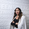 Honoree Binh Nguyen standing in front of white wall featuring names of Philadelphia neighborhoods