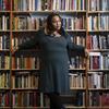 Honoree Sabriaya Shipley wearing a green dress and leaning against a bookshelf