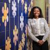 Honoree Sydney Smith standing in the hallway of the school where she teaches. She's leaning on a flower mural.