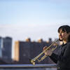 Honoree Bell Thompson with her trumpet and the New York City skyline behind her