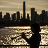 Silhouette of honoree Bell Thompson playing her trumpet in front of the New York City skyline
