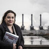 Honoree Brittney Martinez holding a book and standing in front of a treatment plant