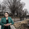 Brittney Martinez standing in a park and wearing a green blazer