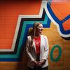 Honoree Marisa Brisbane wearing a University of Maryland t shirt and standing in front of a mural