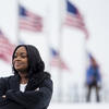 Carine Wellington poses in front of American flags.