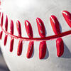 a close up image of a white baseball with red stitching