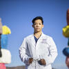 Bihn Le wearing a white labcoat and standing in the Las Vegas desert