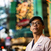 Honoree Bihn Le wearing a white lab coat and standing on the Vegas strip