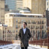 Honoree Alex Cagle wearing a long coat and walking in a city