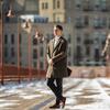 Alex Cagle wearing a long winter coat and standing in front