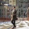 Honoree Alex Cagle wearing a long winter coat and walking in a city