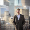Honoree Alex Cagle wearing a long winter coat and walking in the city