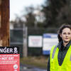 Rebecca Feldman poses for a photo next to a warning sign.