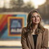 Angelina Neely sits in front of ALDI signage. 
