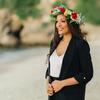 Honoree Jian Joyner wearing a flower crown and standing on a beach looking at the water
